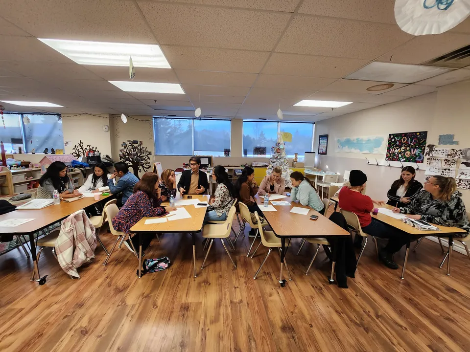 Families and educators gathered in a bright classroom at the centre