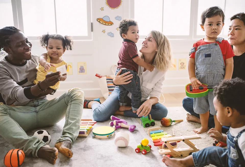 Educators sitting on the floor playing with toddlers