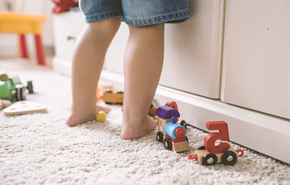 A toddler pushing a toy train