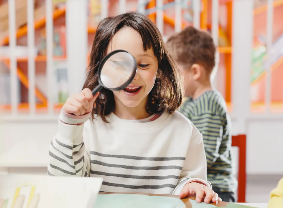 A girl looking through a magnifying glass